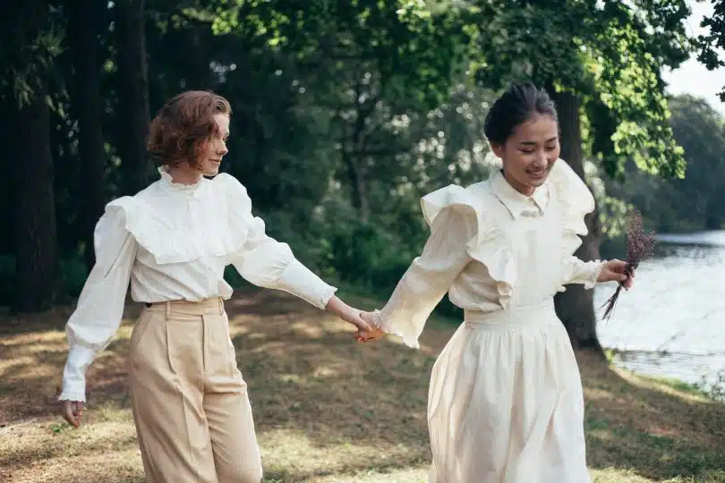 Women in Old-Fashioned Clothing Holding Hands in Park