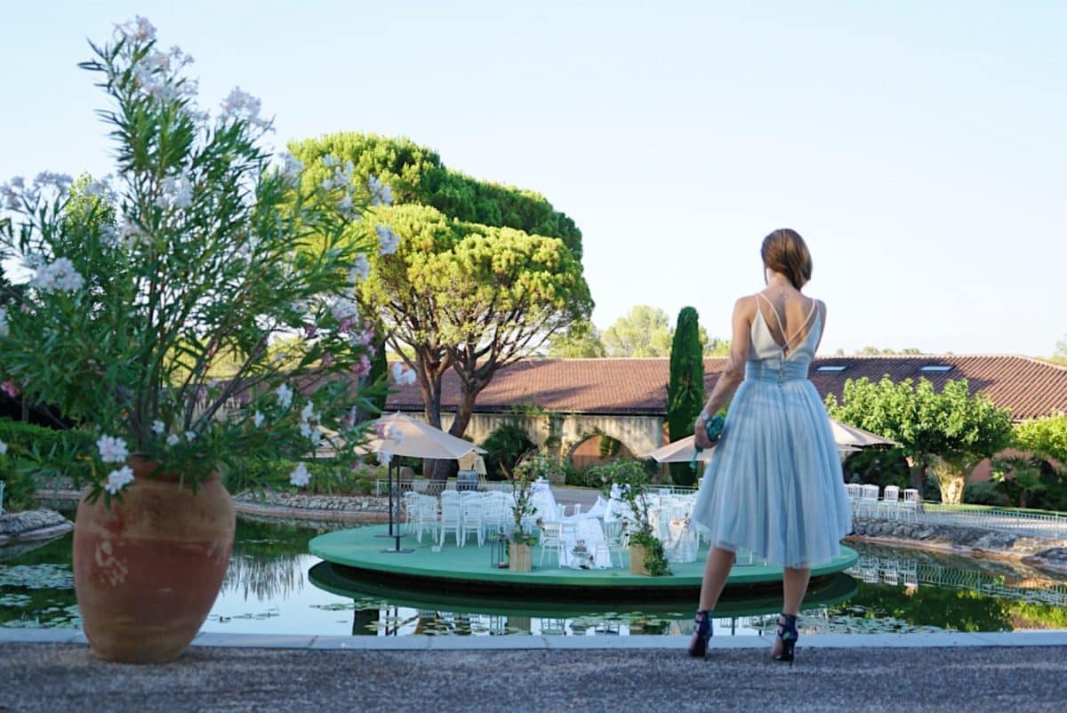 Une demoiselle vêtue de sa robe d'invitée à un mariage dans un jardin