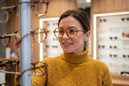 Femme portant des lunettes rondes originales en écaille de tortue dans une boutique d'optique moderne