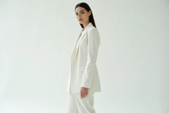 Mannequin femme grande taille photographiée en pied dans un studio blanc lors d'une séance photo éditoriale, portant un blazer structuré et un pantalon tailleur