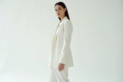 Mannequin femme grande taille photographiée en pied dans un studio blanc lors d'une séance photo éditoriale, portant un blazer structuré et un pantalon tailleur