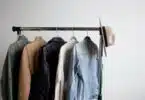 one cowboy hat and five jackets hanged on clothes rack