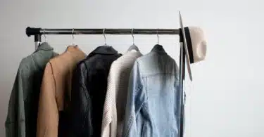 one cowboy hat and five jackets hanged on clothes rack